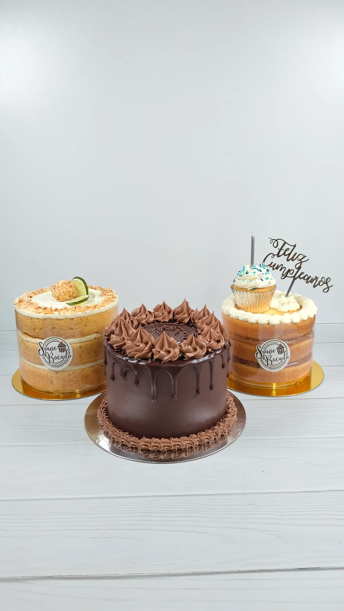 Tres tortas juntas: una de chocolate con rosetas en el centro y dos de capas a la vista a los lados