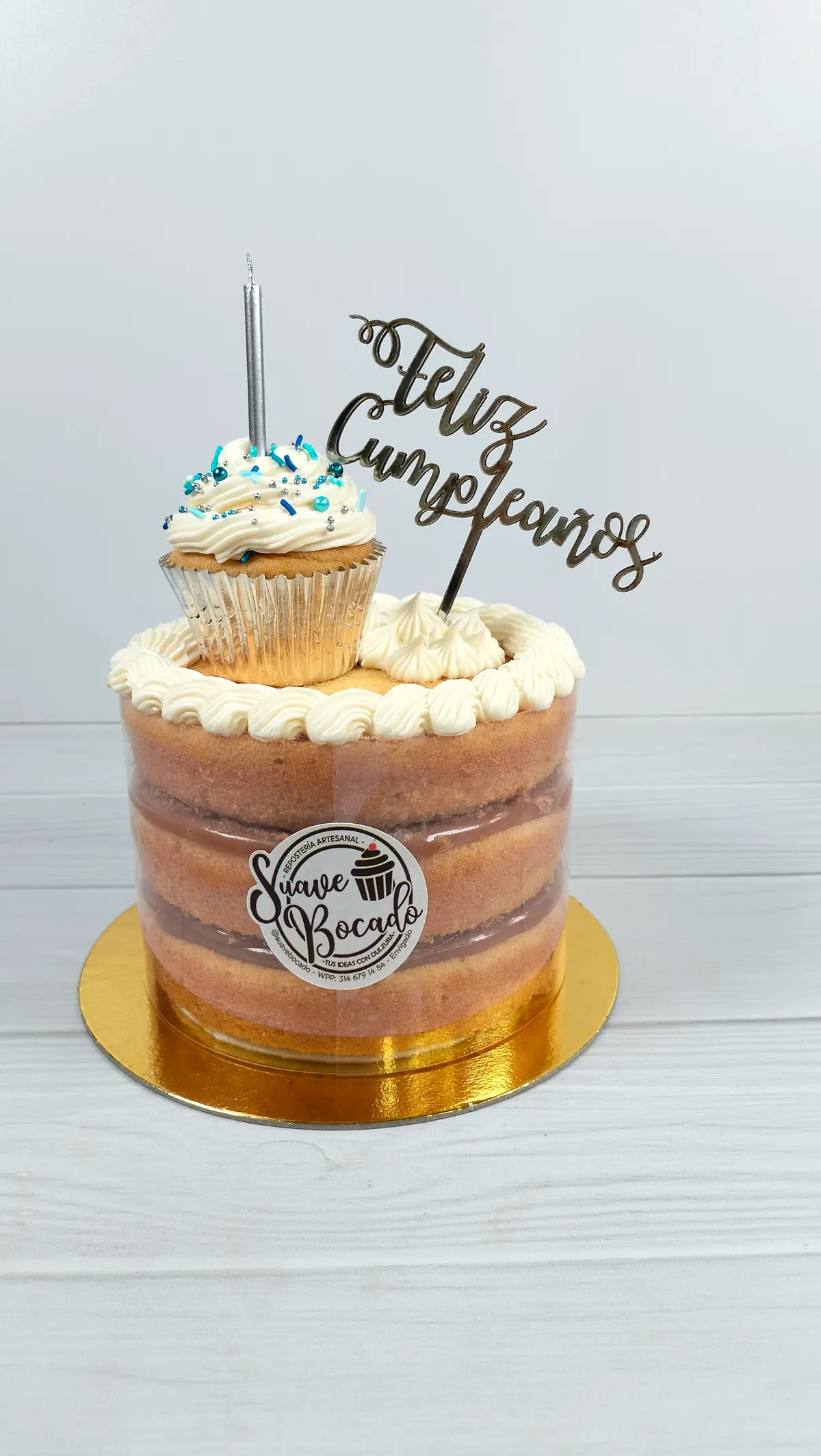Torta de capas a la vista con crema, una vela y un topper de Feliz cumpleaños