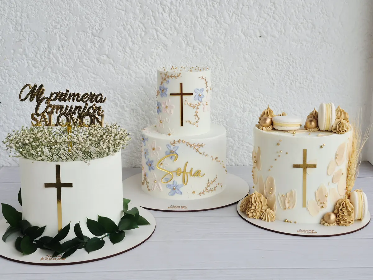 Tres tortas de primera comunión blancas con cruces doradas y flores