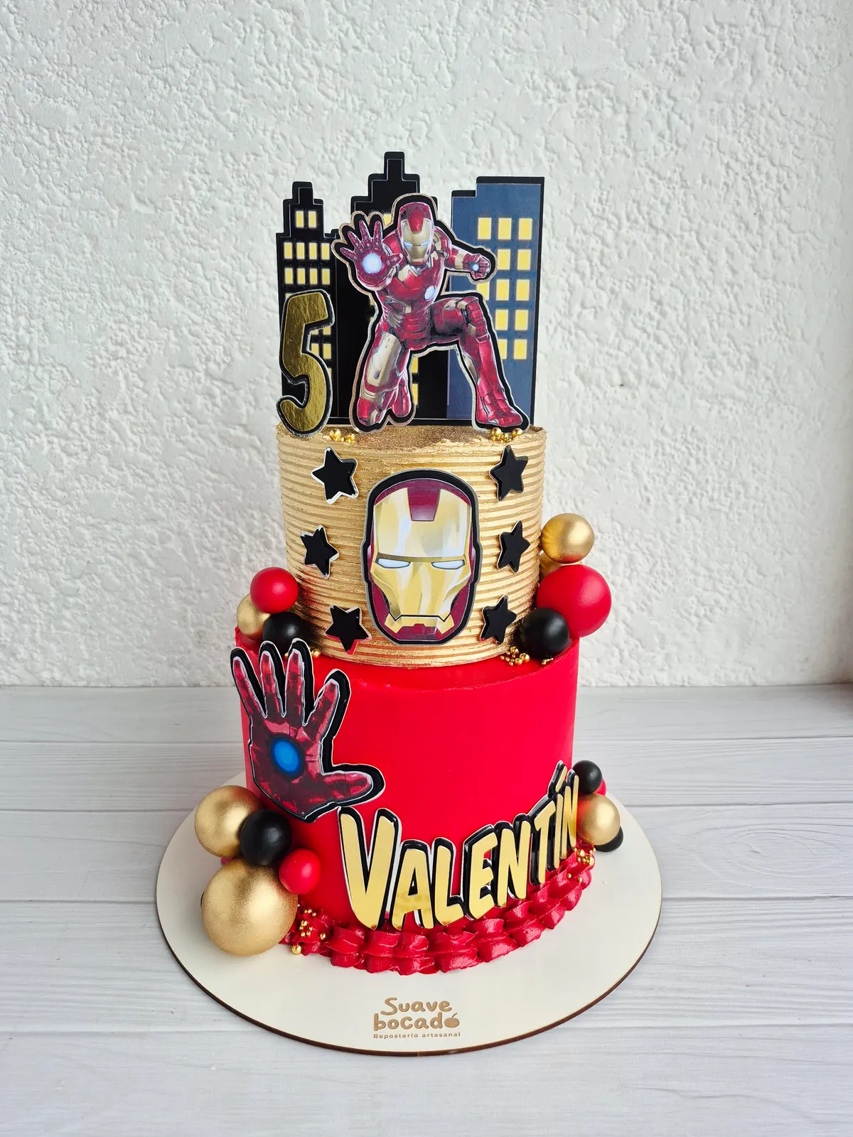 Torta de Iron Man de dos pisos en rojo y dorado, con estrellas, esferas y el nombre Valentín