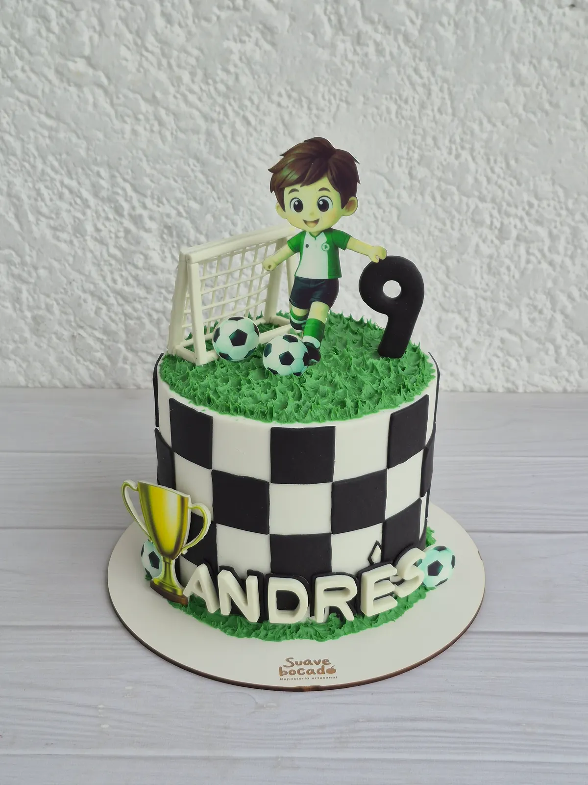 Torta de fútbol con cuadros blancos y negros, pasto, arco, un jugador, un 9 y el nombre Andrés