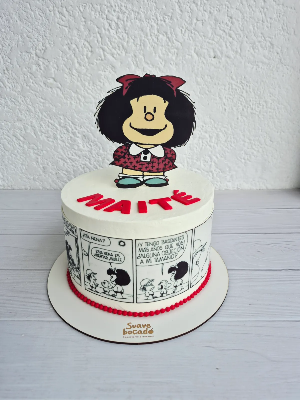 Torta de Mafalda con sus tiras cómicas alrededor y el nombre Maité en rojo